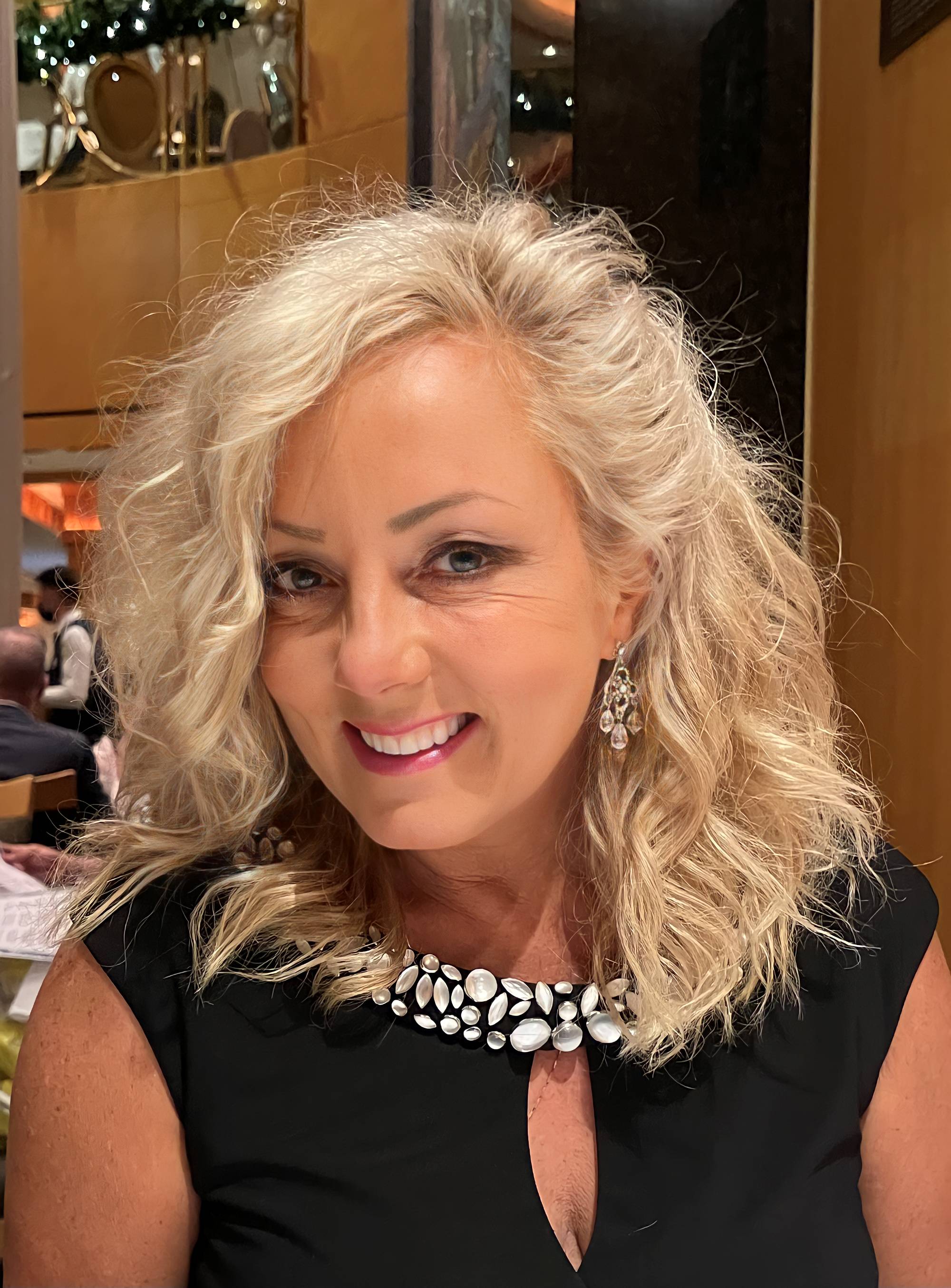 Lorie Tuma in a black dress and necklace